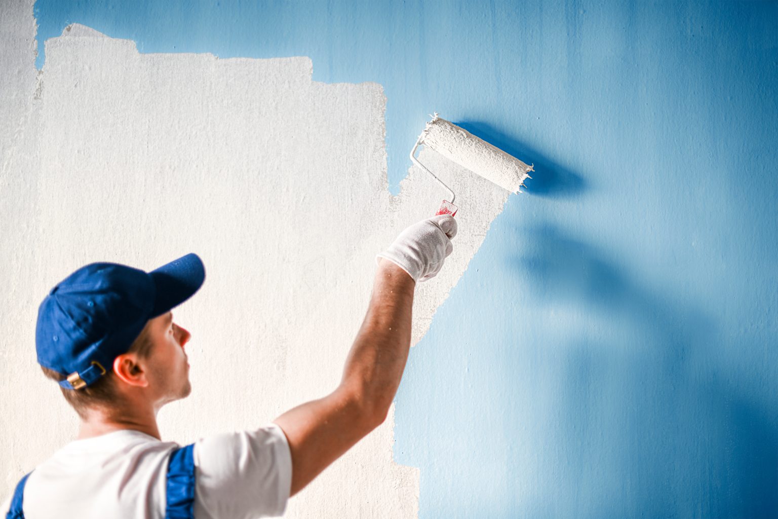 Professional painter rolling a fresh coat on an interior wall