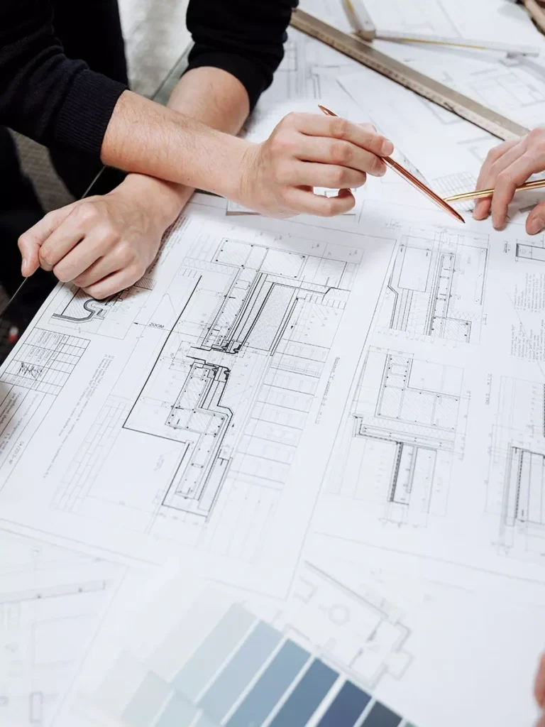 Two people reviewing building blueprints and paint swatches